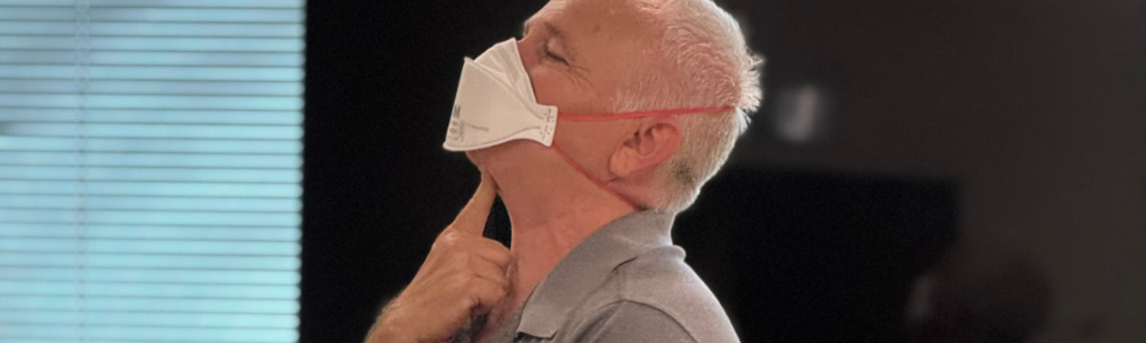 MaskFit+ instructor demonstrating where the bottom of the mask must be folded down and there cannot be any facial hair interrupting the seal.