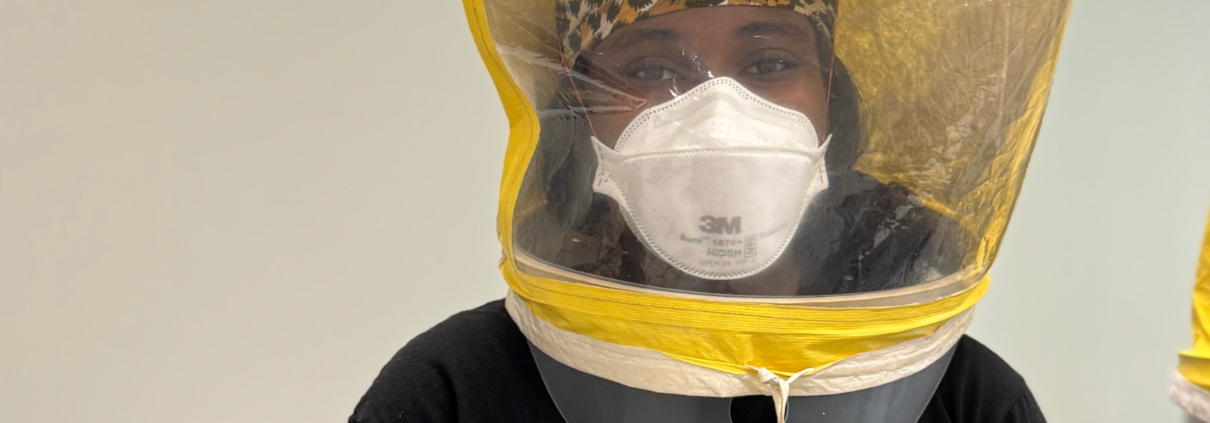 Close-up of a participant wearing a 3M Aura 1870+ N95 respirator beneath a yellow qualitative fit-testing hood.