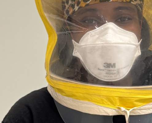Close-up of a participant wearing a 3M Aura 1870+ N95 respirator beneath a yellow qualitative fit-testing hood.